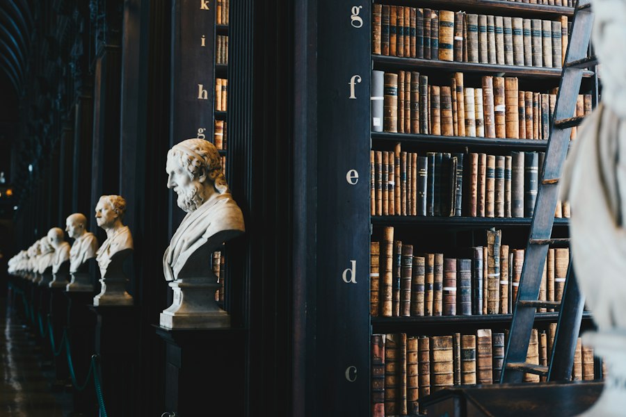 Biblioteca clássica com livros jurídicos e bustos de mármore